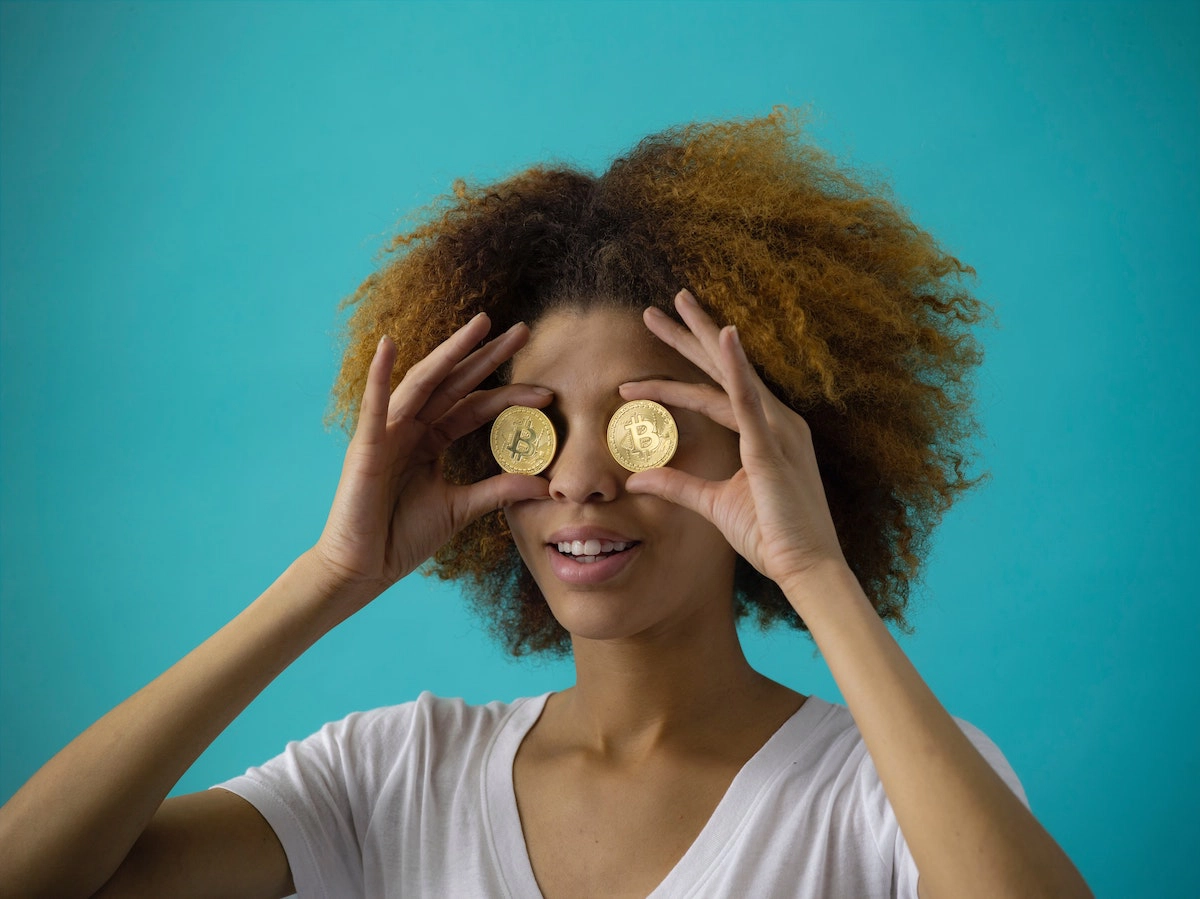a woman holding two coins in front of her eyes